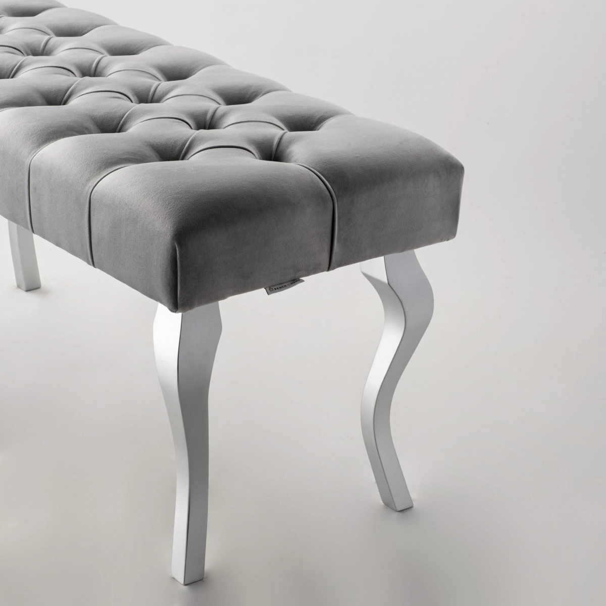 Banc gris matelassé avec pieds chromés brillants