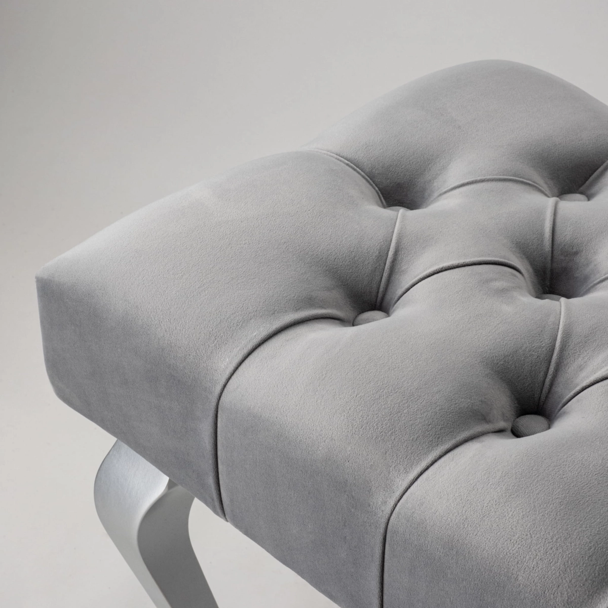 Banc matelassé gris avec pieds chromés brillants