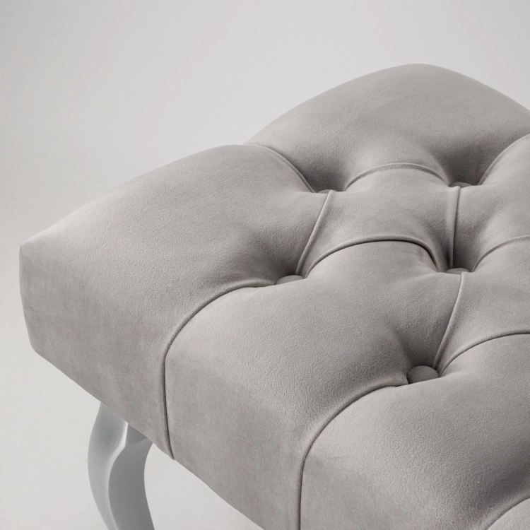 Élégant banc gris rembourré avec pieds argentés