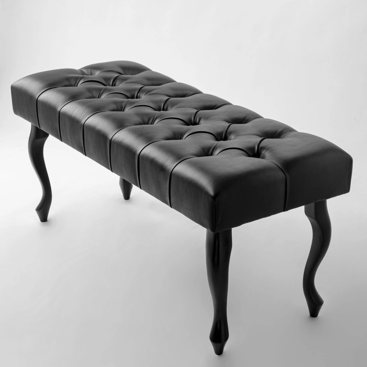 Banc matelassé noir avec revêtement en cuir, une combinaison de fonctionnalité et d'élégance intemporelle.