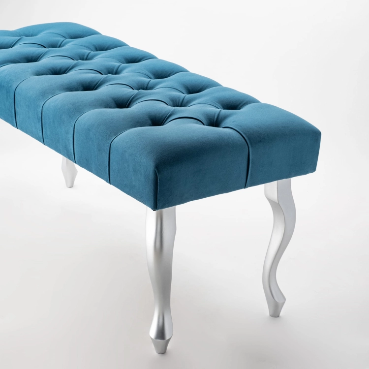 Banc matelassé de couleur turquoise intense avec pieds argentés