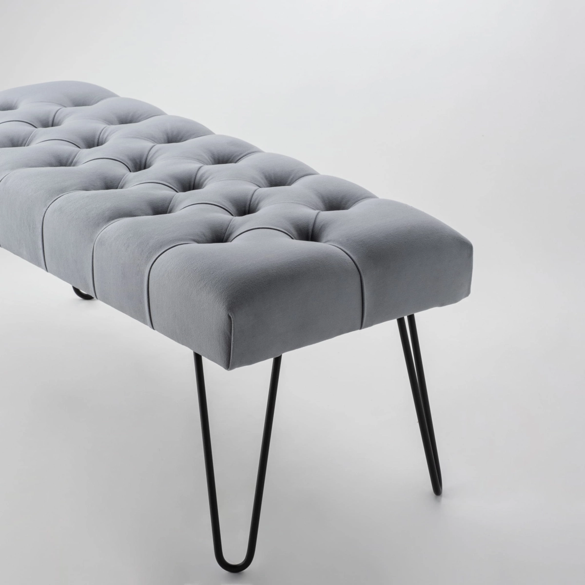 Banc gris élégant avec un siège capitonné et des pieds en métal