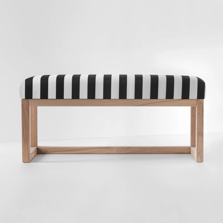 Banc rembourré à rayures noires et blanches avec une étagère et un cadre en bois clair