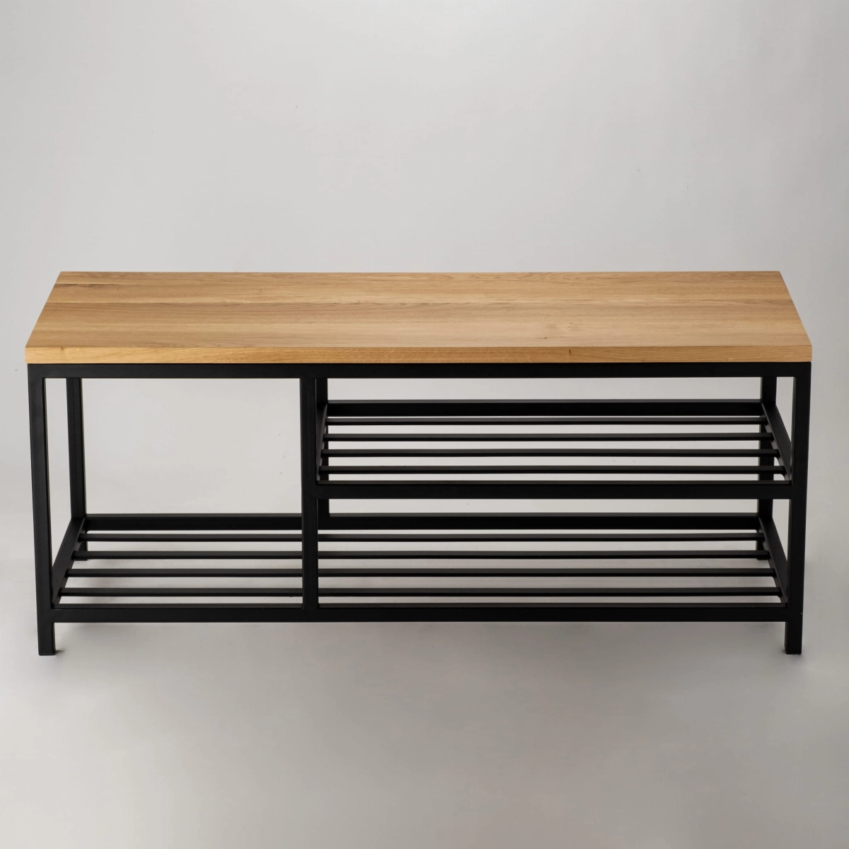 Un banc minimaliste avec un plateau en bois et deux étagères ajourées.